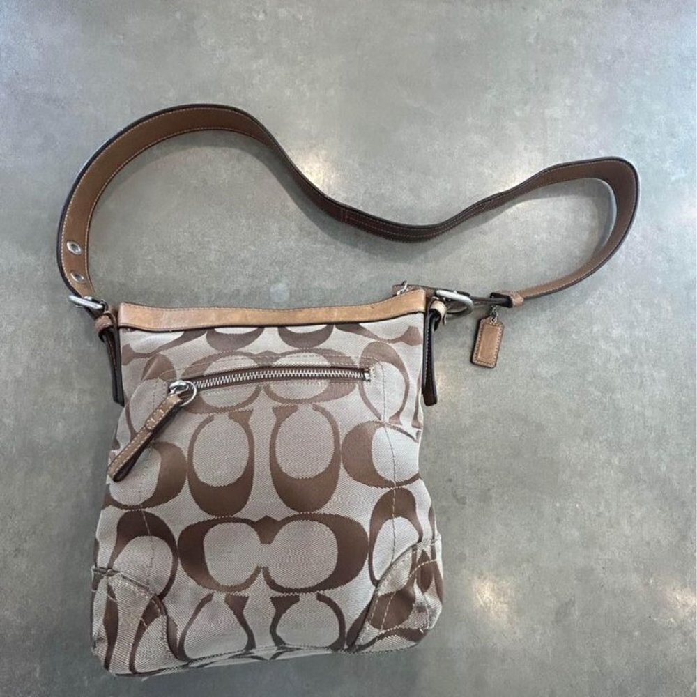 COACH- woman’s crossbody bag. Signature logo. Adjustable strap. Full zipper.